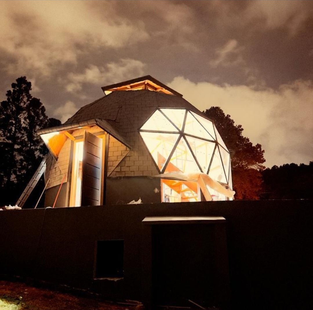 Domo geodésico iluminado em implantação noturna